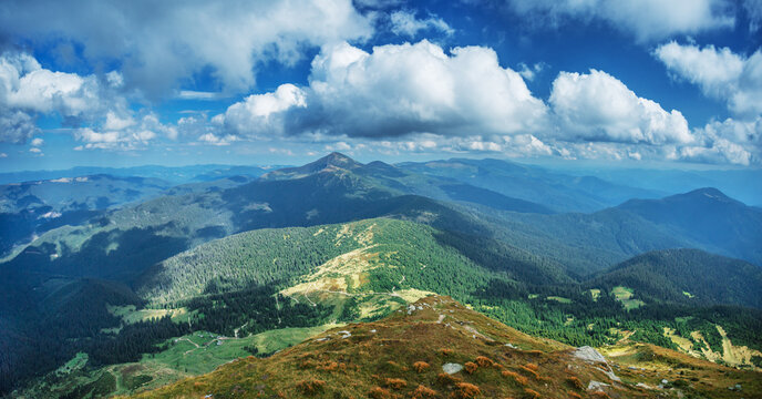 Beautiful mountain landscape of The Carpathian Mountains and cloudy blue sky over them.