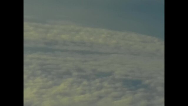 view from the window of an airliner clouds landscape and wings of the plane in the 70s