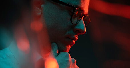 Cinematic night closeup portrait of handsome man neon lights. Fashion, style, human emotions,...