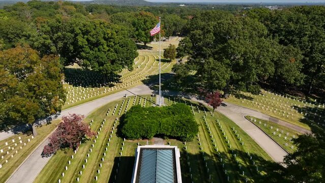 National Military Cemetery. Buried soldiers from US armed forces. USA flag with headstones and grave markings for those who gave ultimate sacrifice.