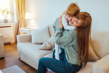 Mother hug her daughter in home. Close up of happy young mother hug cuddle little daughter, loving smiling biracial mom embrace small child, enjoy tender family moment, motherhood, childcare concept