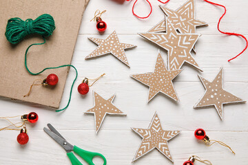 Cardboard stars with Christmas balls on white wooden background