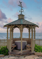 Vertical Puffy clouds at sunset Gazebo with built in seat and table in a beautiful garden at La
