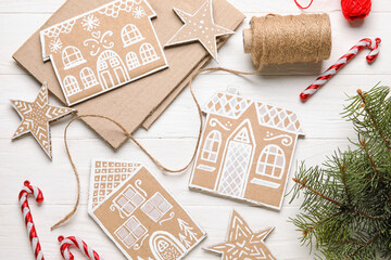 Christmas cardboard toys with candy canes and fir branches on white wooden background