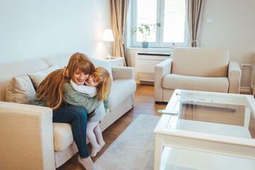 Mother and daughter having fun time in living room. Closeup photo of cute small girl young charming...