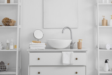 Fototapeta na wymiar Shelf units with different bath accessories and modern sink near white wall