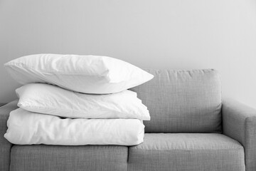Fototapeta na wymiar Stack of blanket and pillows on comfortable sofa