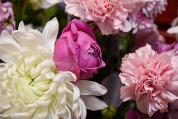 Beautiful holiday card from different flowers. Close-up of a bouquet of white chrysanthemum flowers, pink peonies and carnations. Floral background