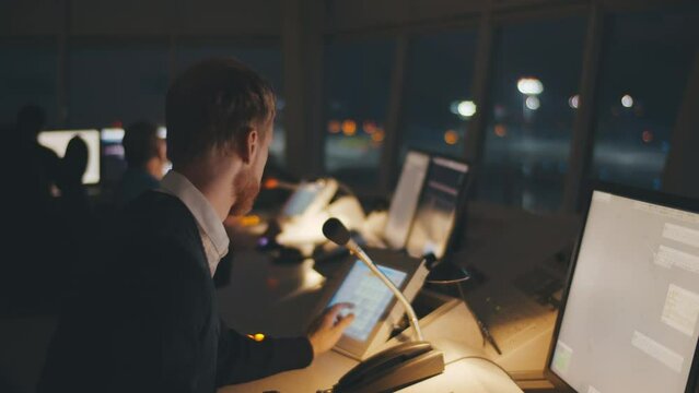 Close up of traffic control center operator working in airoport tower at night