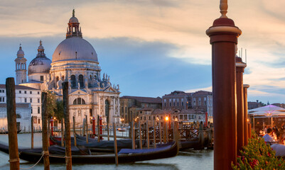 Venezia. Facciata della Salute sul Canal Grande con gondole e pali al crepuscolo