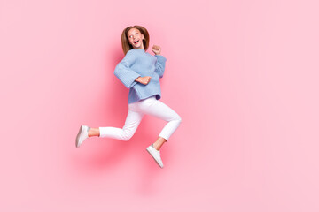 Full body size photo of young beautiful funky teenager wear blue knitted sweater run fast look empty space curious isolated on pink color background