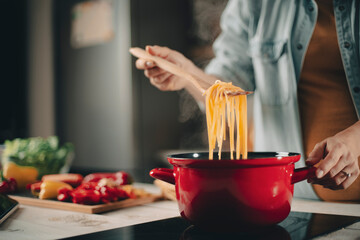 Beautiful pregnant woman preparing delicious food. Smiling woman preparing delicious food..