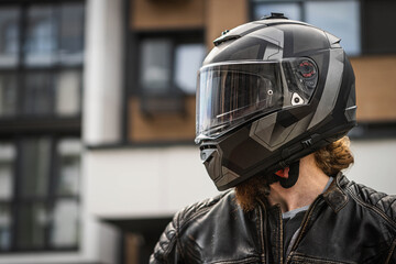 Biker in protective helmet looks away, photo in profile