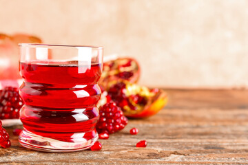 Glass of fresh pomegranate juice on wooden table