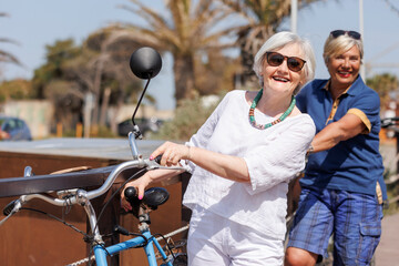 coppia di anziane signore si diverte felice con le proprie biclette vintage