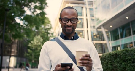 Black man, phone and walking, drink coffee in city and happy for online communication, reading news or typing email. African man, smile and freelancer morning, drinking tea and 5g mobile network - Powered by Adobe