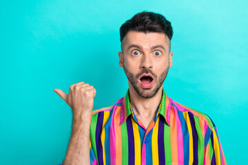 Portrait photo of young attractive brunet hair guy wear colorful retro shirt open mouth finger direct mockup news isolated on cyan color background