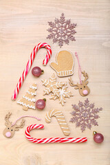 Christmas tree made of cookies, candy canes and decorations on wooden background
