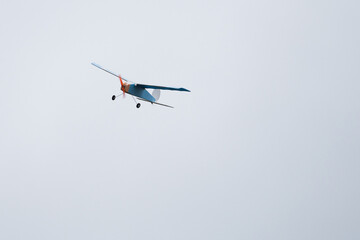 Radio-controlled model aircraft in the air makes a turn - front view