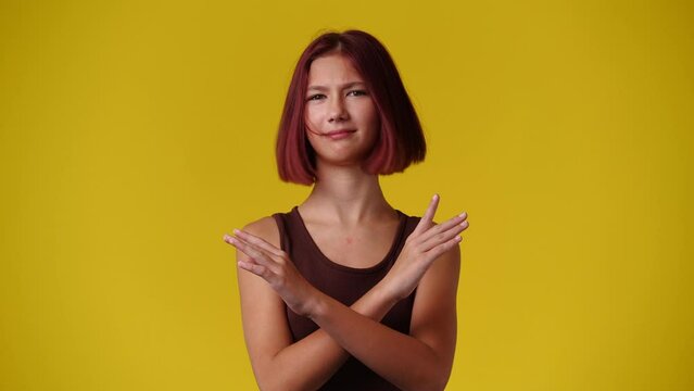 4k video of one girl with crossed hands on yellow background.