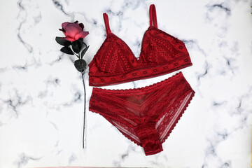 Sexy lace red glamorous lingerie with red ribbon decoration on white fur background, woman shopping and fashion female wardrobe concept. Woman accessories. Gift presents, self care concept