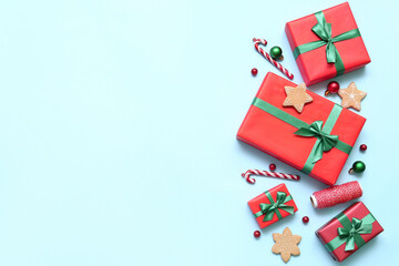 Gift boxes with Christmas decor and cookies on blue background