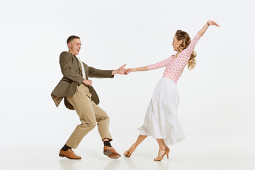 Two emotional dancers in vintage style clothes dancing swing dance, rock-and-roll or lindy hop isolated on white background. 1960s american fashion style and art. - obrazy, fototapety, plakaty