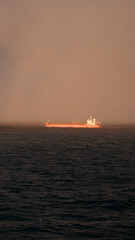 Baltic Sea, Europe - 10 31 2022: Red coloured oil tanker spotted underway during the dense fog...
