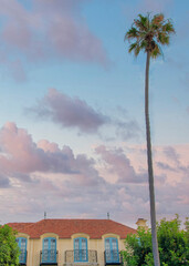 Vertical Puffy clouds at sunset Old mediterranean mansion at La Jolla, California with vines on