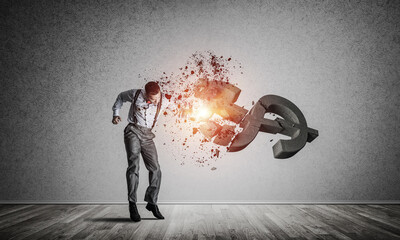 Determined banker man in empty concrete room breaking dollar figure