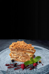 A piece of Napoleon cake with berries and mint