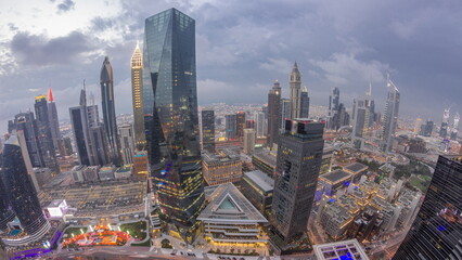 Naklejka na ściany i meble Panorama of futuristic skyscrapers after sunset in financial district business center in Dubai day to night timelapse