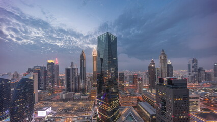 Obraz premium Panorama of futuristic skyscrapers after sunset in financial district business center in Dubai day to night timelapse