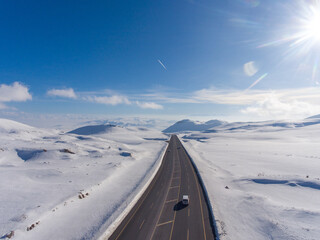 Aerial view of road under the snow featuring cold, temperature, and winter. Adventure of a road trip concept