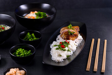 Various dishes of Asian cuisine with different types noodles and rice with shrimp, duck, vegetables and black sesame