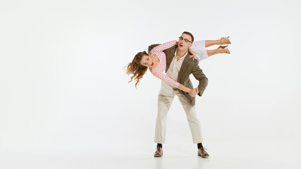 Young excited man and woman in 60s american fashion style clothes dancing retro dance isolated on...