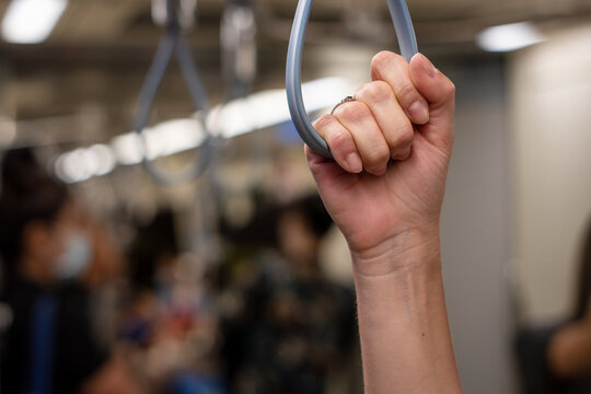 Pasajera tomando pasamanos mientras viaja en subte	