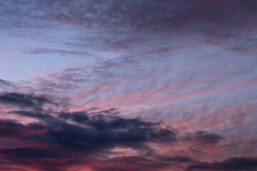 Pink and purple tinted  clouds on blue sky at sunset in Minnesota.
