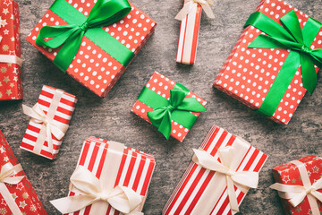 Fototapeta premium A lot of Christmas gift boxes in colored paper decorated on table, Top view close up. Many present New Year gift