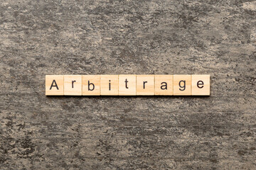 Arbitrage word written on wood block. Arbitrage text on cement table for your desing, concept