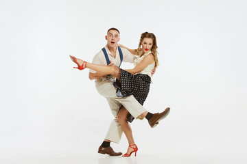 Two emotional dancers in vintage style clothes dancing swing dance, rock-and-roll or lindy hop isolated on white background. 1960s american fashion style and art.