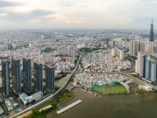 Fototapeta premium Top view aerial photo from flying drone of a Ho Chi Minh City with development buildings, transportation, energy power infrastructure. Financial and business centers in developed Vietnam.