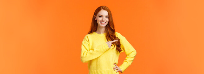 Shopping, consumer and holidays concept. Cheerful attractive redhead woman in yellow sweater invite...
