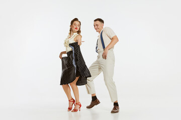 Two emotional dancers in vintage style clothes dancing swing dance, rock-and-roll or lindy hop isolated on white background. 1960s american fashion style and art.