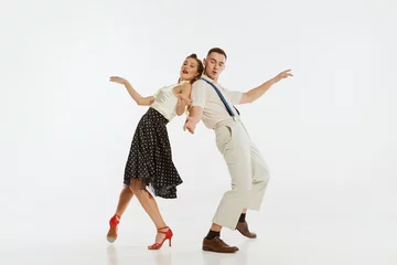Photo sur Plexiglas École de danse Young excited man and woman in 60s american fashion style clothes dancing retro dance isolated on white background. Music, energy, happiness, mood, action