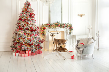 Stylish white living room interior with decorated Christmas tree, fireplace and sofa with pillows. Christmas at home. New year winter home decor. Xmas tree with lights glowing garlands and gifts	