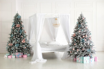 Modern white bedroom in Skandinavian style with bed with flowing white curtains and two decorated christmas tree. Concept new year and holidays. Interior design bedroom. Winter Xmas Hygge home decor	