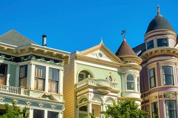 Row of deorative buildings with colorful facades in the historic districts of San Francisco California in midday sun neighborhood