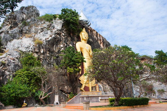 Carving stone and sculpture golden big buddha image statue of Wat Tham Khao Ngu temple for thai people travel visit respect praying blessing holy at limestone mountain rock park in Ratchaburi Thailand