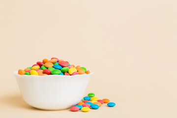 Multicolored candies in a bowl on a colored background. birthday and holiday concept. Top view with copy space
